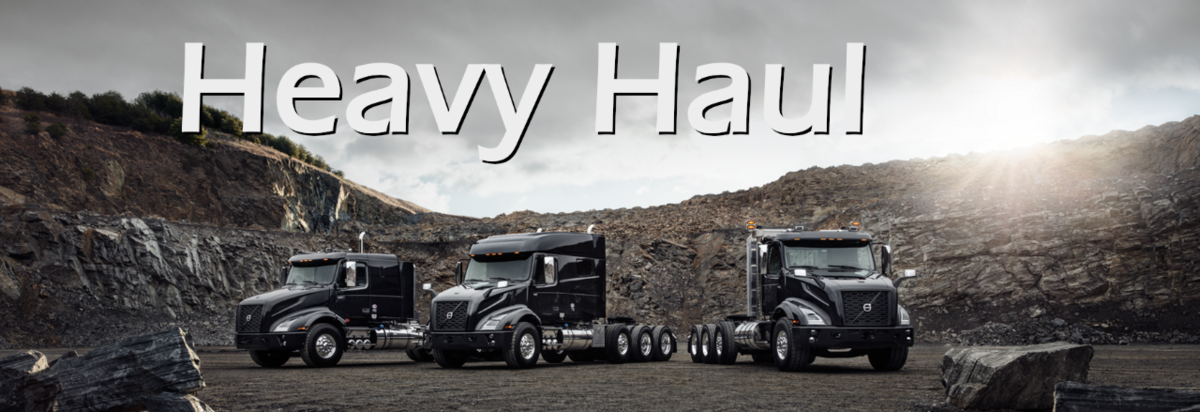 The word Heavy Haul over three large trucks